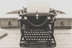 Vintage Remington Standard typewriter with a blank sheet on a wooden desk