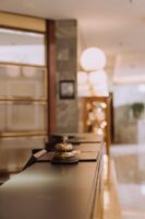Who Provides Audit and Advisory Services for Hospitality and Leisure Companies? Big Four, Mid Tier and Specialist Firms (2025) Bell on a hotel counter