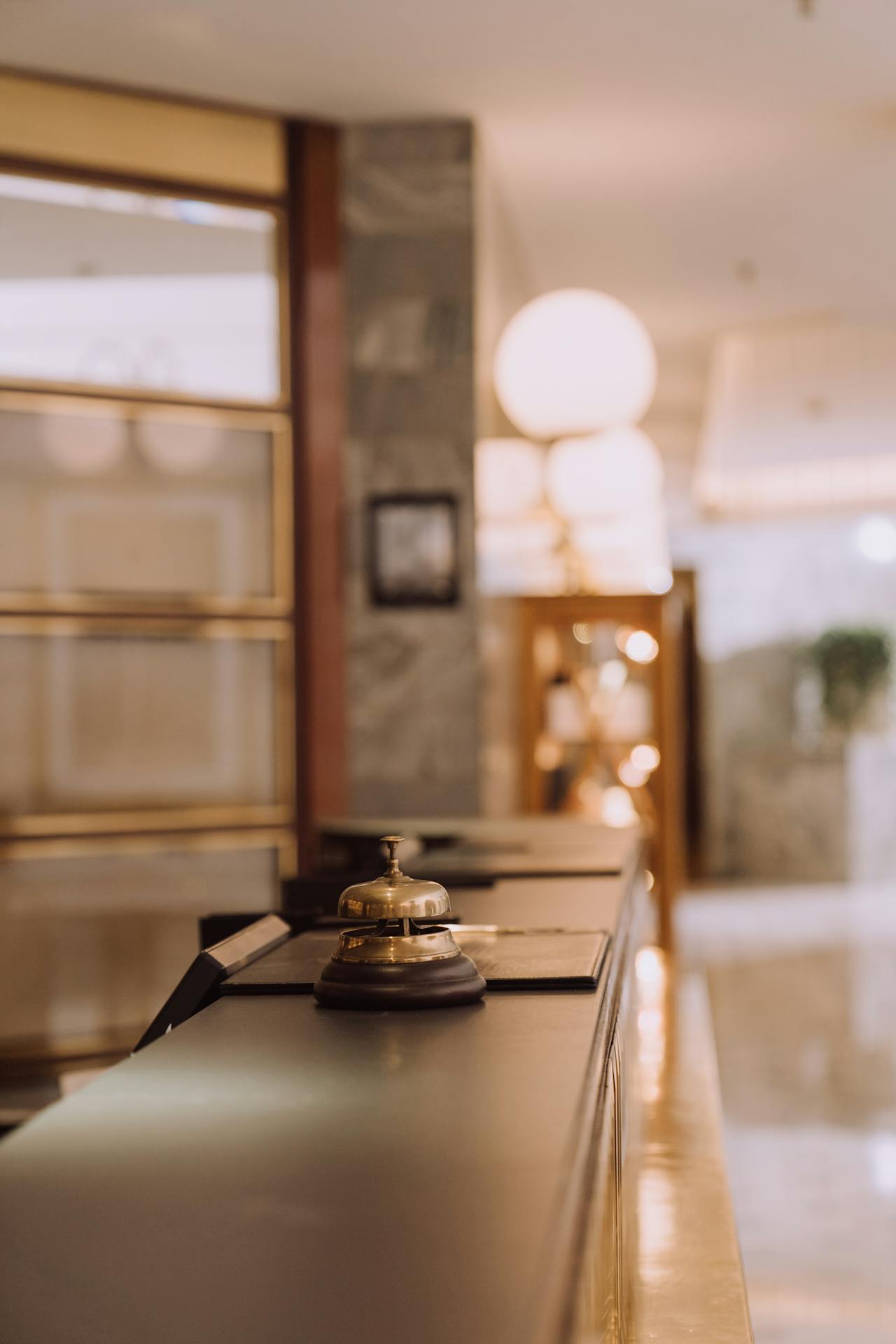 Who Provides Audit and Advisory Services for Hospitality and Leisure Companies? Big Four, Mid Tier and Specialist Firms (2025) Bell on a hotel counter