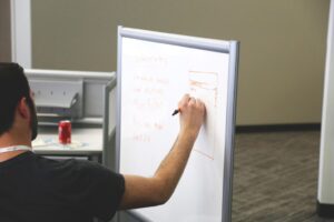 Image of man writing on a whiteboard