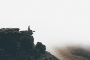 Image of man sitting on rock ledge