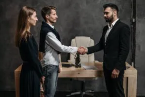 Image of three people with two of them shaking hands