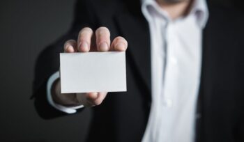 Image of man in business suit holding up a card