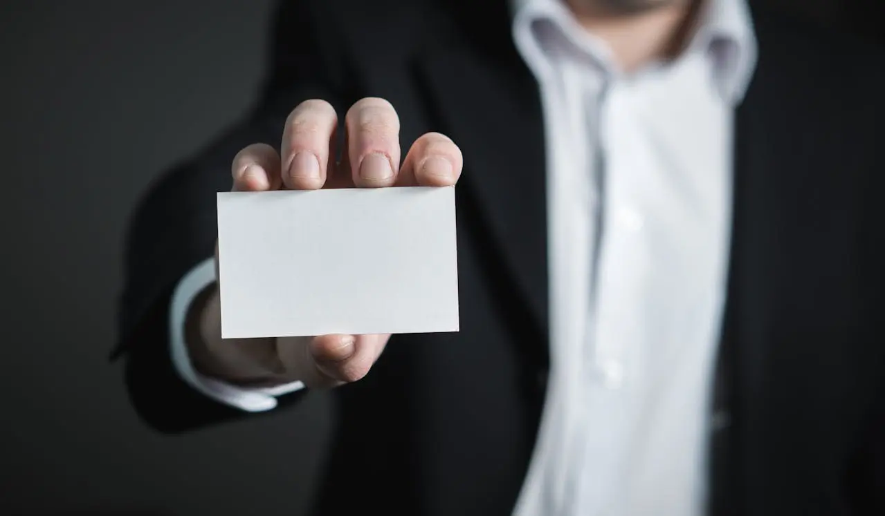Image of man in business suit holding up a card
