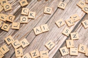 Scrabble tiles on a wooden board spelling AI