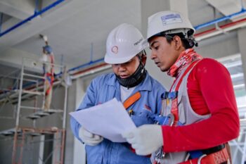 Image of two construction workers looking at papers