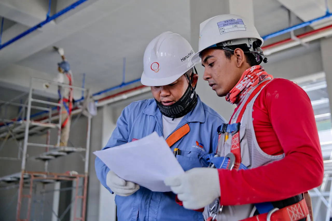 Image of two construction workers looking at papers
