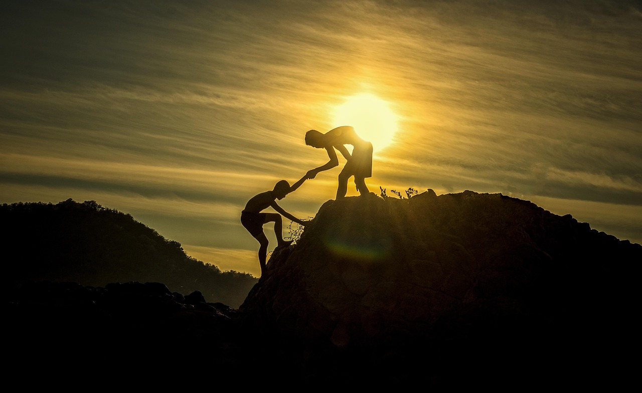 Two people climbing a mountain